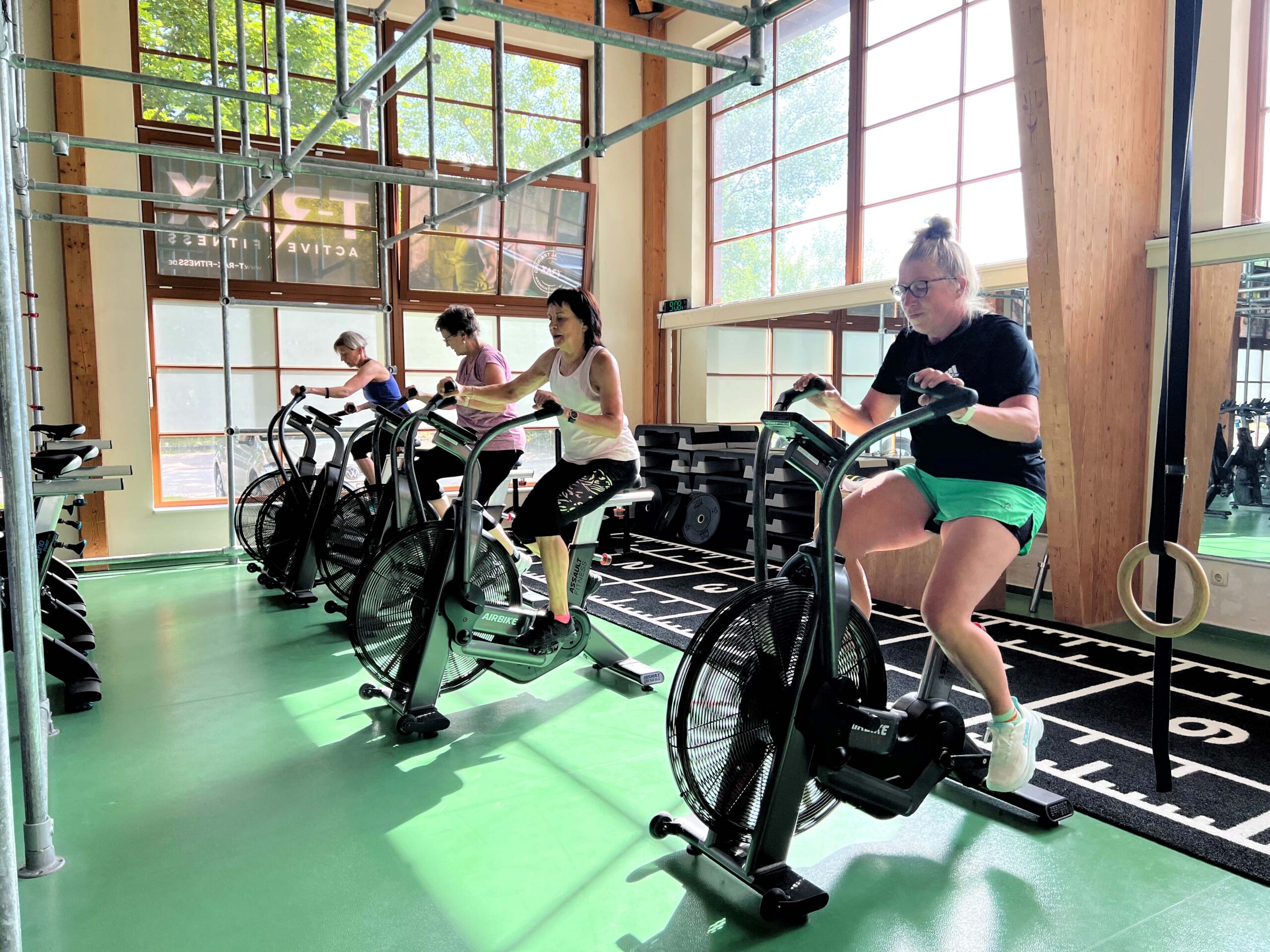 Gruppenkurs. Teilnehmerinnen sitzen auf einem Crosstrainer.