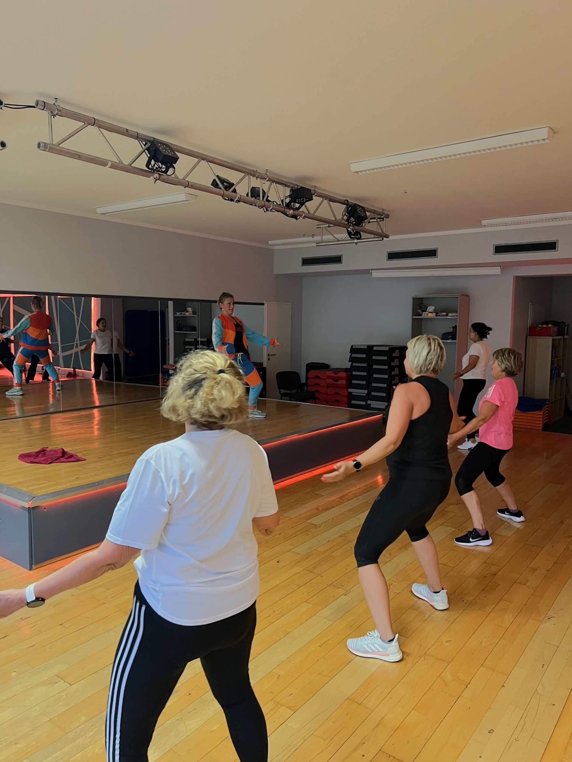Gruppenkurs. Kursleiterin leitet den Zumba-Kurs an